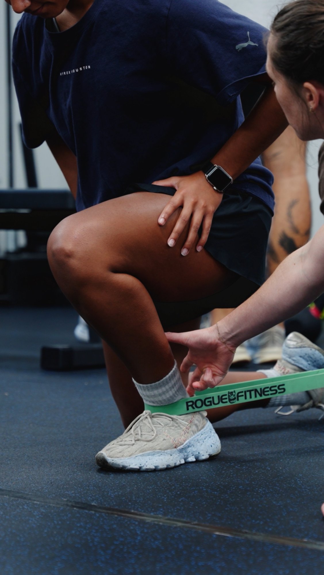 Fort Worth orthopedic physical therapist assisting athlete with kettlebell deadlift during injury rehabilitation Fort Worth orthopedic physical therapist assisting athlete with kettlebell deadlift during injury rehabilitation